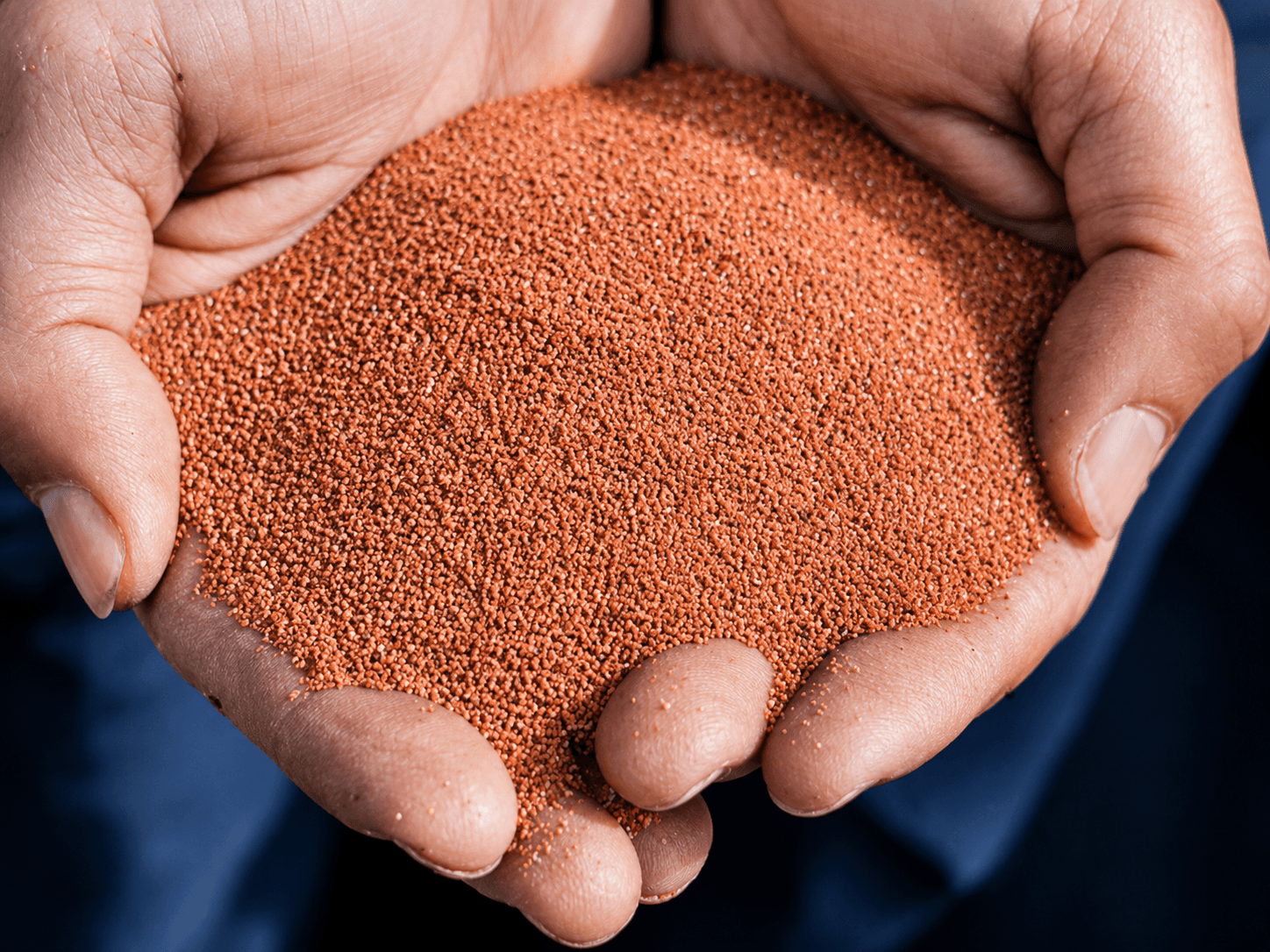 Minerale korrels in handen als materiaal voor een granietinstrooivloer